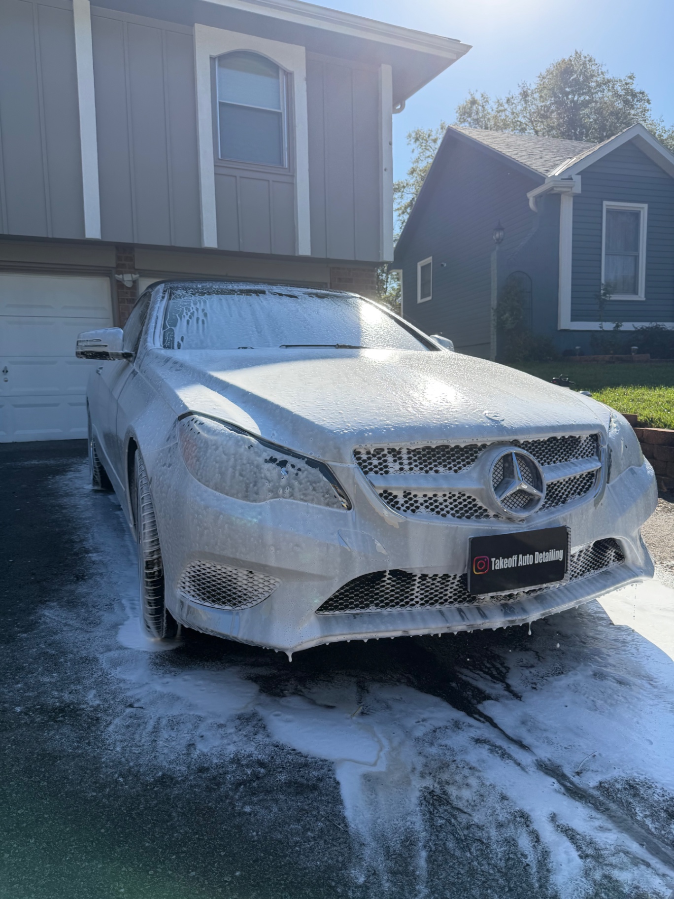 Silver Mercedes coupe wrapped in thick foam during a foam cannon wash